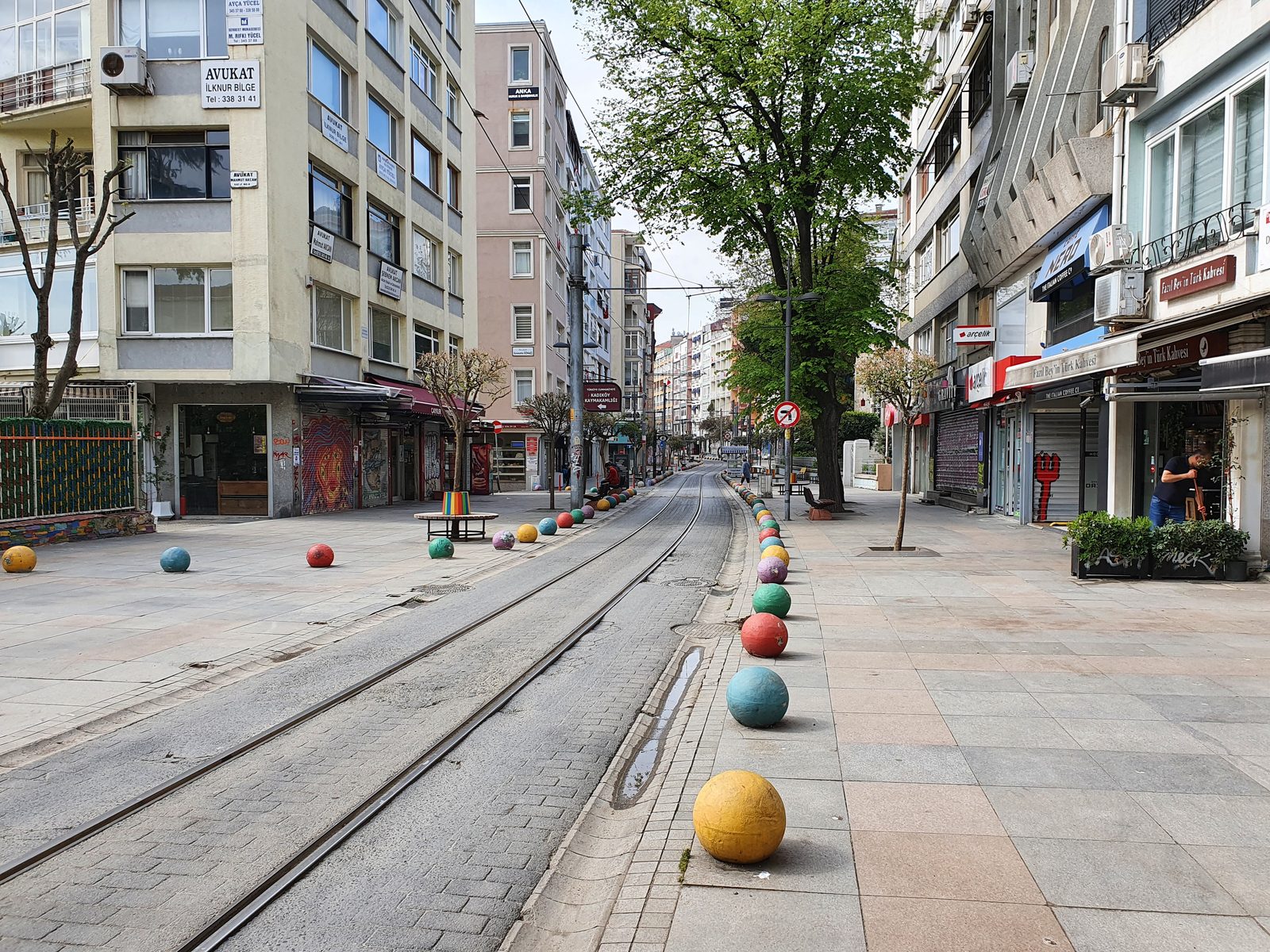 Tram tracks follow Bahariye Street between shops and trees in Kadıköy.
