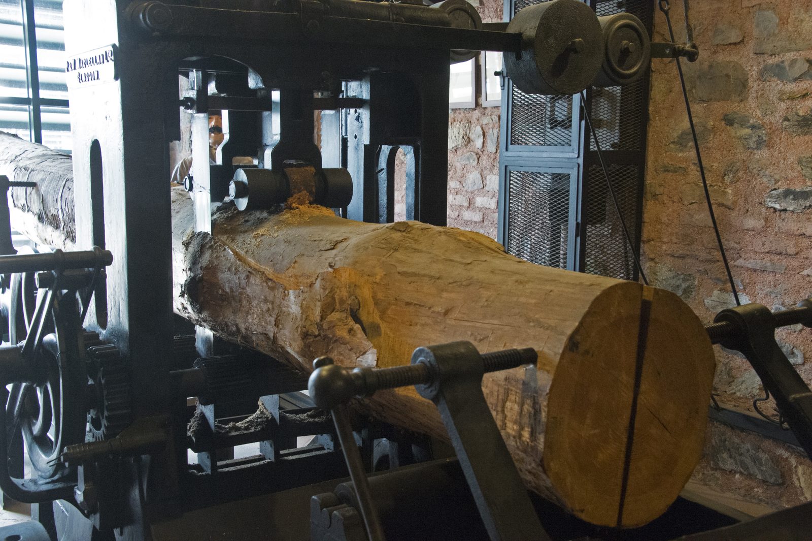 A large log rests on an industrial wood-saw carriage at the Rahmi M. Koç Museum.
