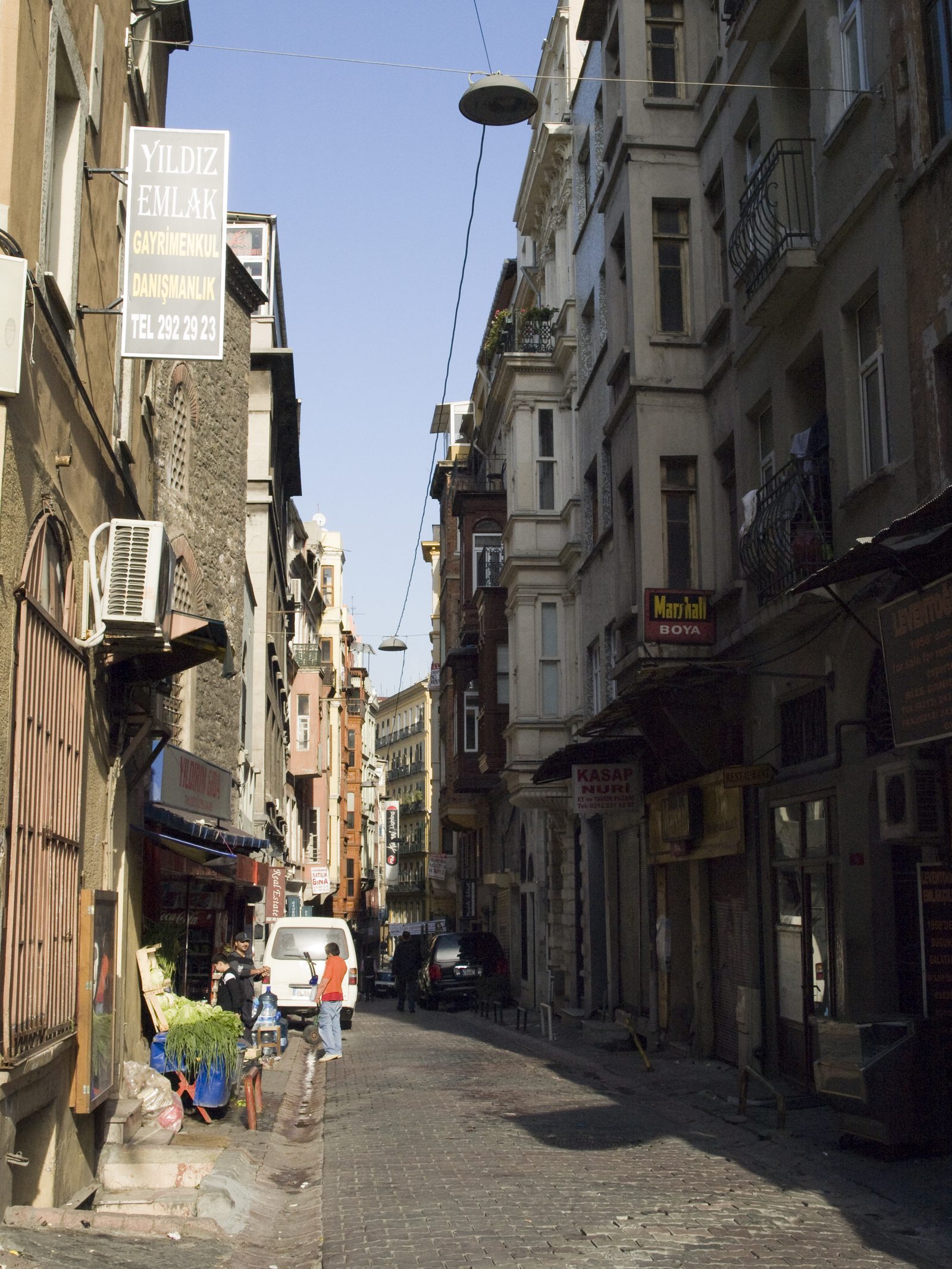 A narrow stretch of Serdar-ı Ekrem Street lined with closely spaced buildings.