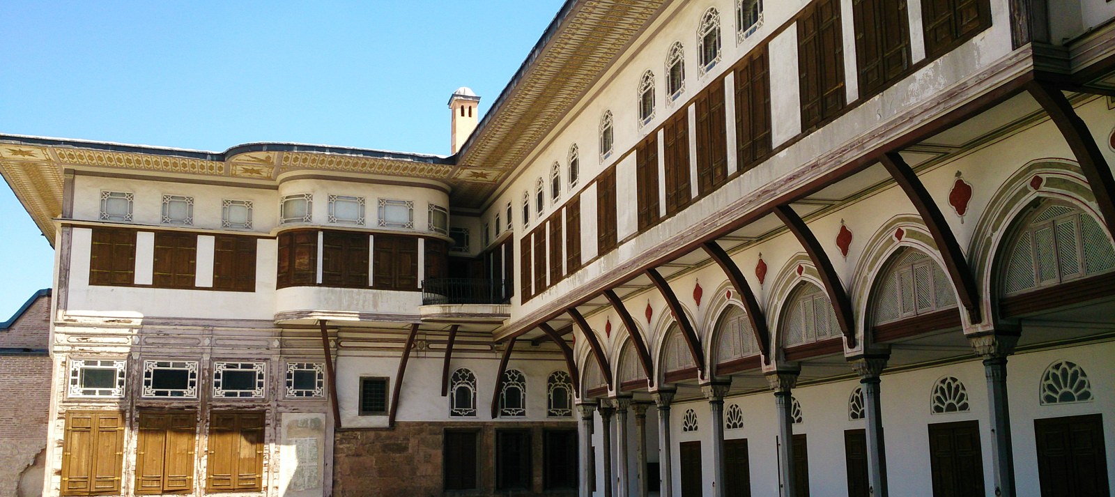 Residential façades and a covered arcade frame a courtyard at Topkapı, photographed in 2014.